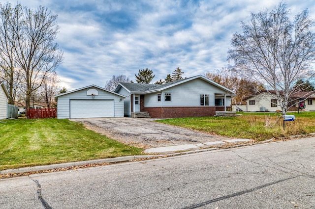 single story home featuring a front yard, fence, a detached garage, and brick siding