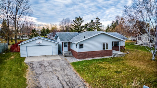 single story home with driveway, brick siding, a front yard, and fence