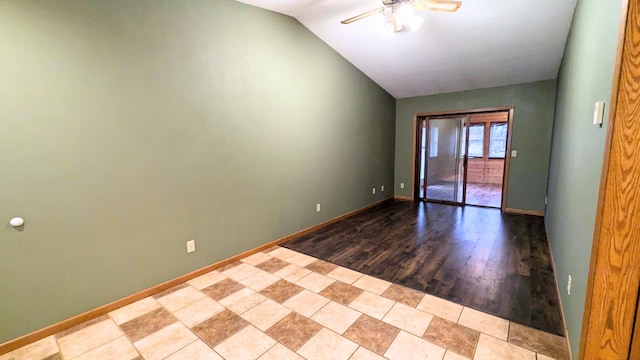 unfurnished room with lofted ceiling, ceiling fan, and baseboards