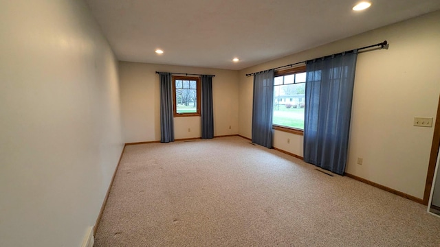 unfurnished room featuring recessed lighting, light colored carpet, visible vents, and baseboards