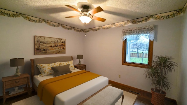 bedroom featuring visible vents, ceiling fan, a textured ceiling, wood finished floors, and baseboards