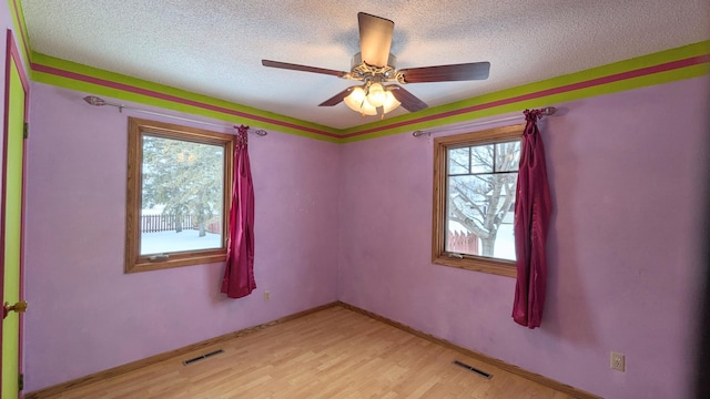 spare room featuring visible vents, a textured ceiling, and light wood finished floors