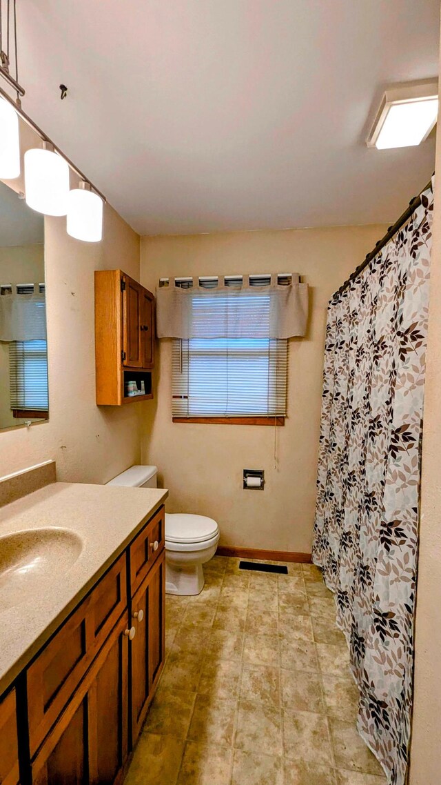 full bathroom with visible vents, a shower with shower curtain, vanity, and toilet