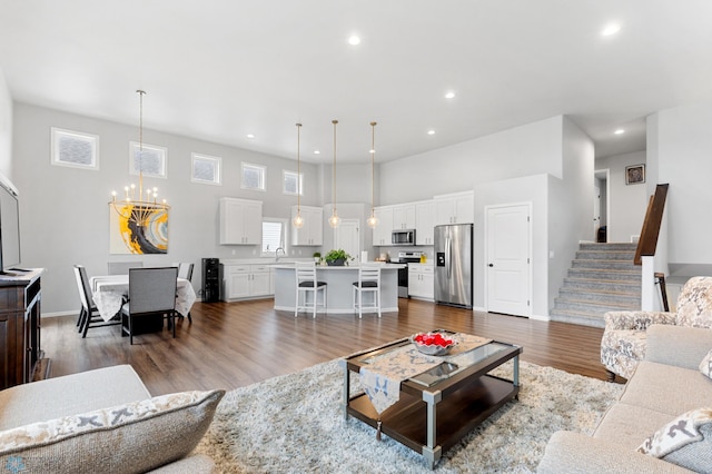 living room featuring a chandelier, a high ceiling, dark hardwood / wood-style flooring, and sink