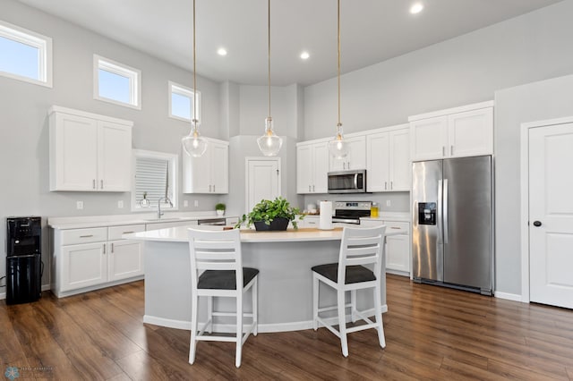 kitchen featuring white cabinetry, stainless steel appliances, a high ceiling, and dark wood-type flooring