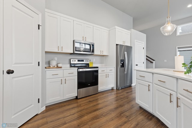 kitchen with dark hardwood / wood-style flooring, white cabinets, hanging light fixtures, and appliances with stainless steel finishes