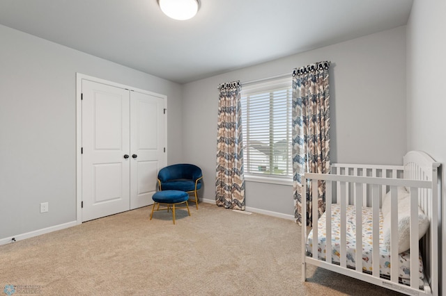 bedroom with a closet, light colored carpet, and a nursery area