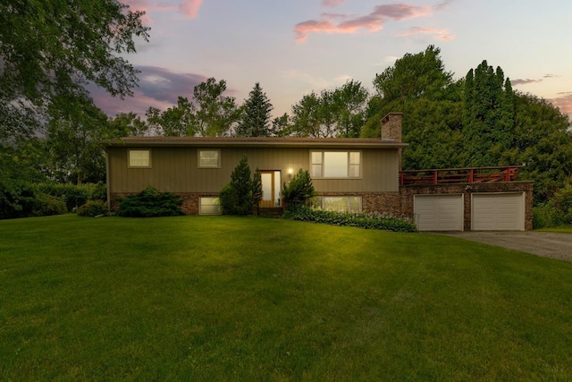 view of front of home with a yard and a garage