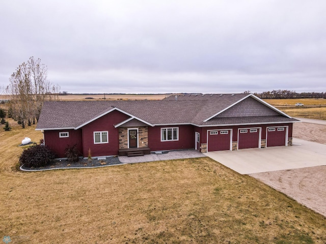 ranch-style home featuring a garage and a front lawn