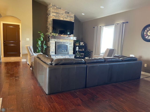 living room featuring a fireplace, dark wood-type flooring, and vaulted ceiling