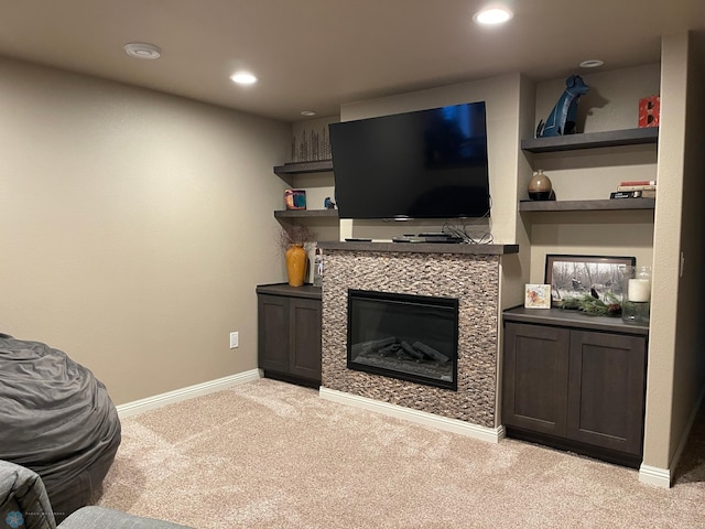 living room featuring a fireplace and light carpet