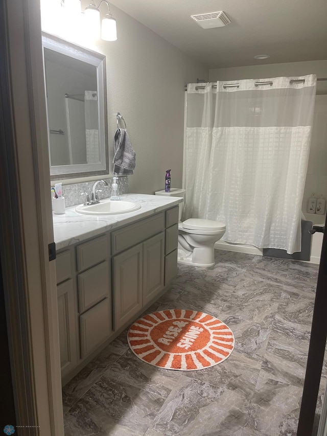 full bathroom featuring shower / bath combo, vanity, and toilet