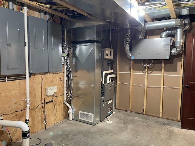 utility room featuring electric panel and heating unit