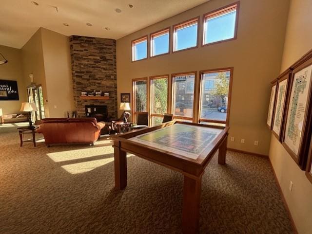 rec room featuring carpet flooring, a fireplace, and a towering ceiling