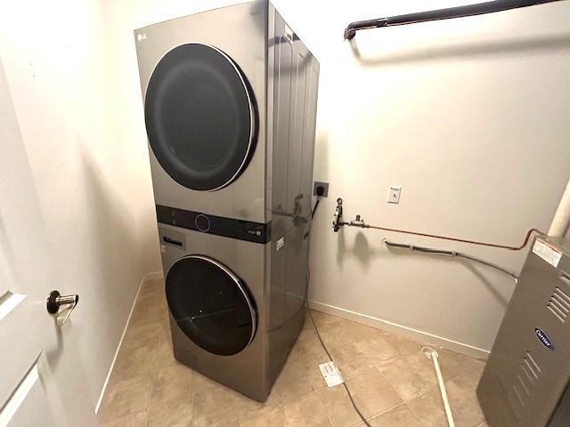 washroom with light tile patterned floors and stacked washer and clothes dryer