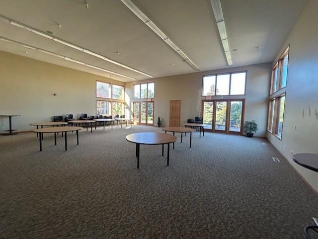 playroom with carpet flooring, a towering ceiling, and a wealth of natural light