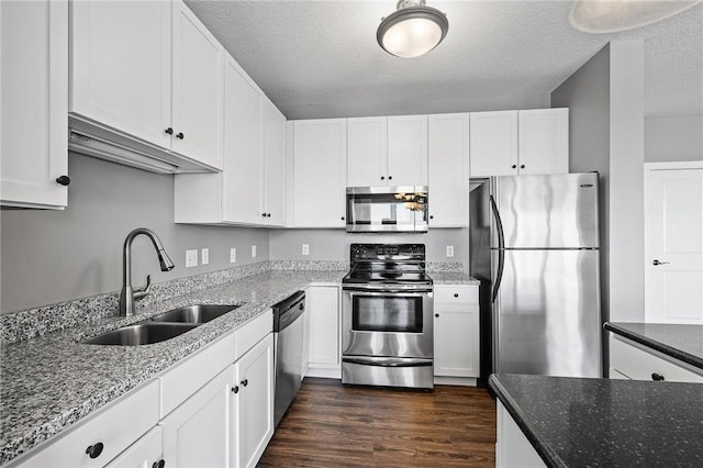 kitchen featuring white cabinets, stainless steel appliances, stone counters, and sink