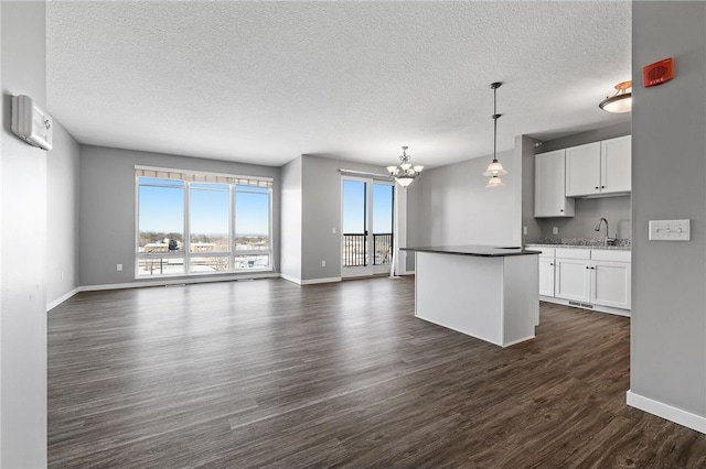 kitchen with sink, white cabinets, decorative light fixtures, and an inviting chandelier