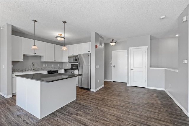 kitchen featuring a center island, hanging light fixtures, dark hardwood / wood-style floors, white cabinets, and appliances with stainless steel finishes