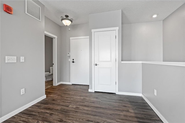 hall featuring dark hardwood / wood-style floors and a textured ceiling