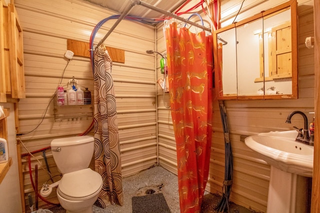 bathroom with curtained shower, wood walls, and toilet