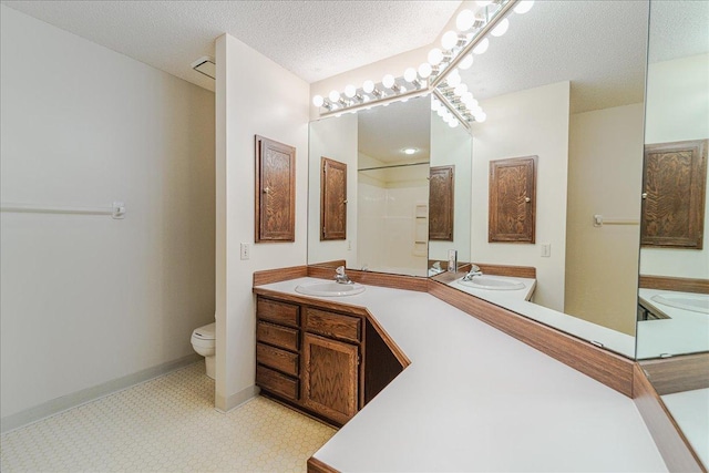 bathroom with walk in shower, vanity, a textured ceiling, and toilet