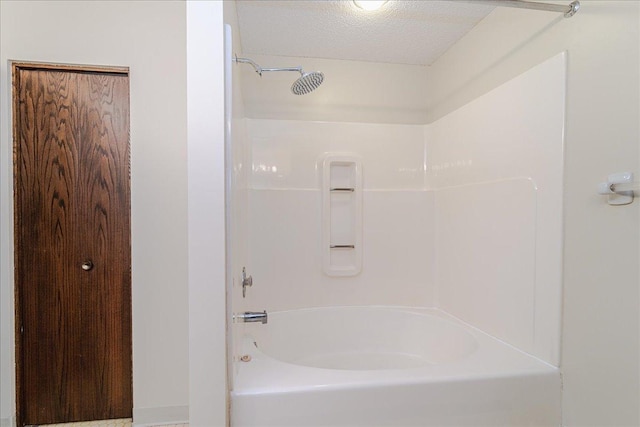 bathroom with a textured ceiling and  shower combination