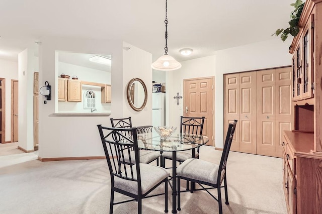 dining area featuring light colored carpet