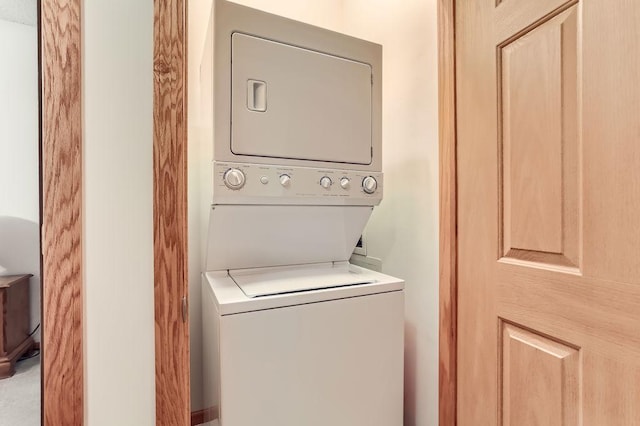 washroom featuring stacked washer / drying machine