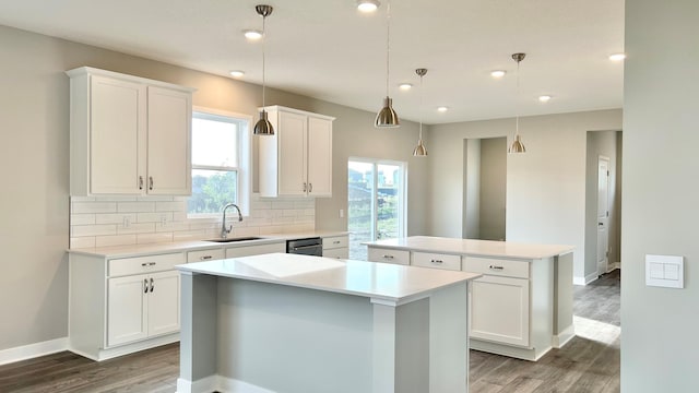 kitchen featuring sink, pendant lighting, white cabinetry, and a center island