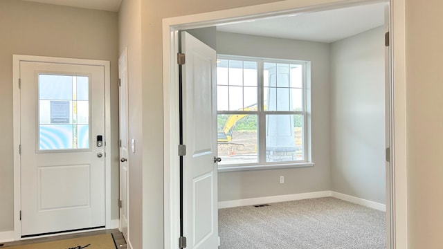 doorway to outside with carpet flooring