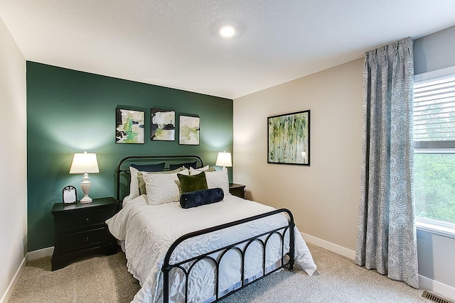 bedroom with light colored carpet and a textured ceiling