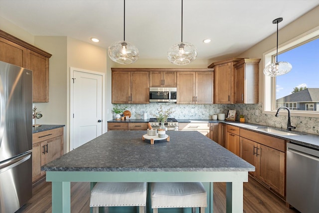 kitchen featuring sink, appliances with stainless steel finishes, hanging light fixtures, and dark hardwood / wood-style flooring