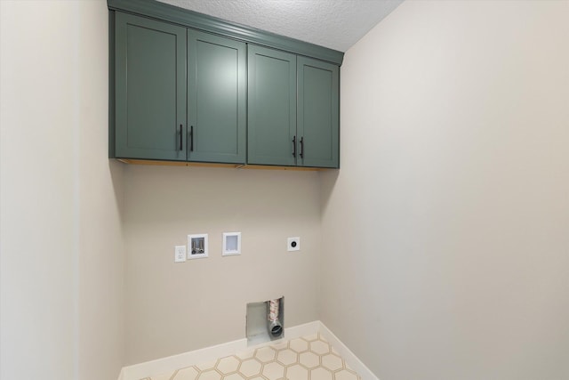 washroom featuring cabinets, hookup for a washing machine, a textured ceiling, and electric dryer hookup