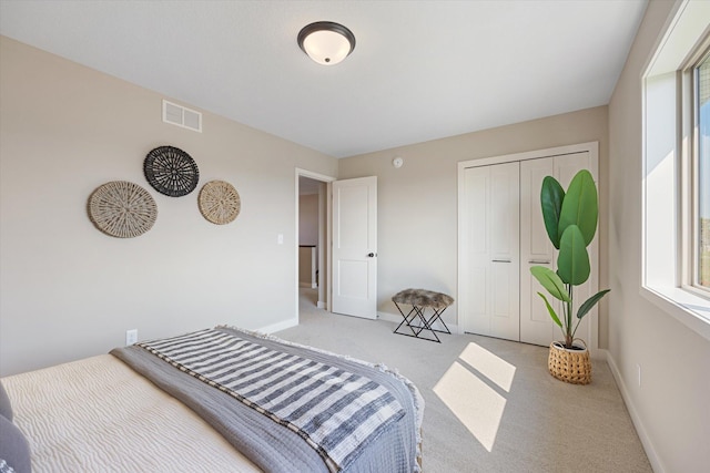 bedroom featuring light carpet and a closet