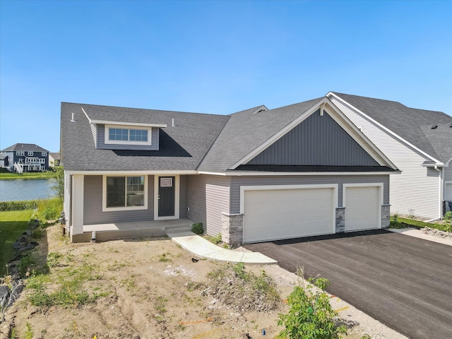 view of front of home with a garage and a water view