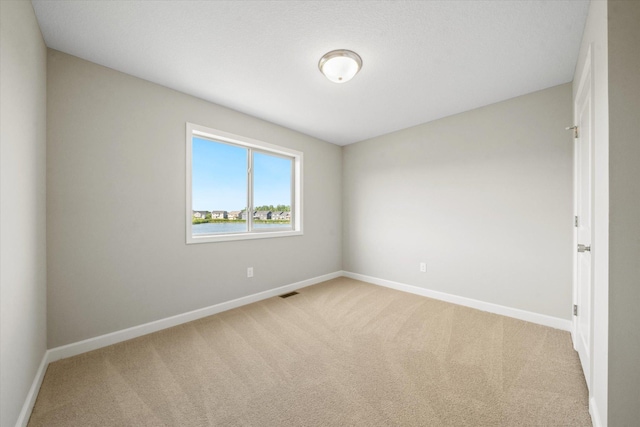 unfurnished room featuring light carpet