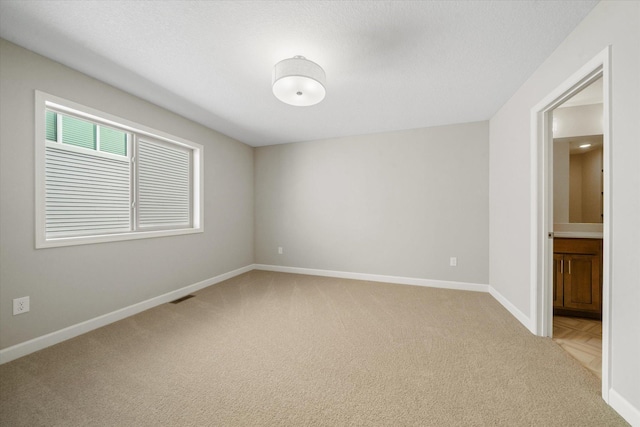 carpeted spare room with a textured ceiling