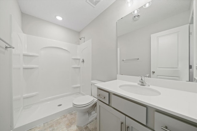 bathroom featuring vanity, toilet, and walk in shower