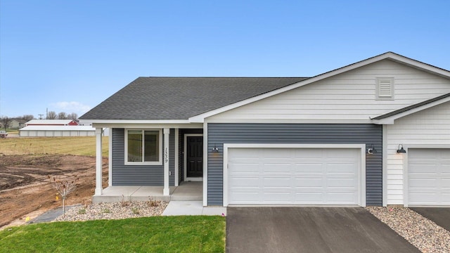 view of front of home featuring a garage, a front lawn, and a porch