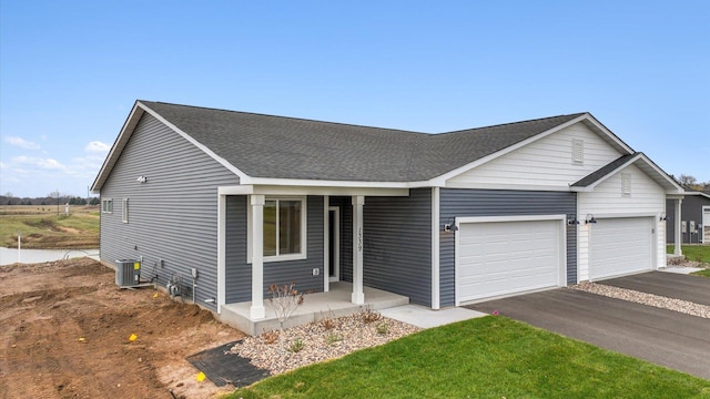 ranch-style home with a garage, a porch, and cooling unit