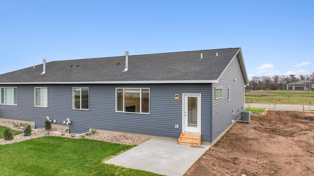 back of house featuring central AC, a yard, and a patio