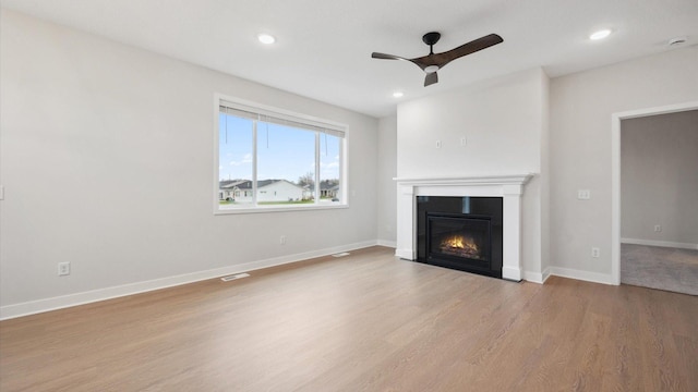 unfurnished living room featuring ceiling fan and light wood-type flooring