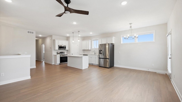 kitchen with a center island, pendant lighting, sink, white cabinetry, and stainless steel appliances