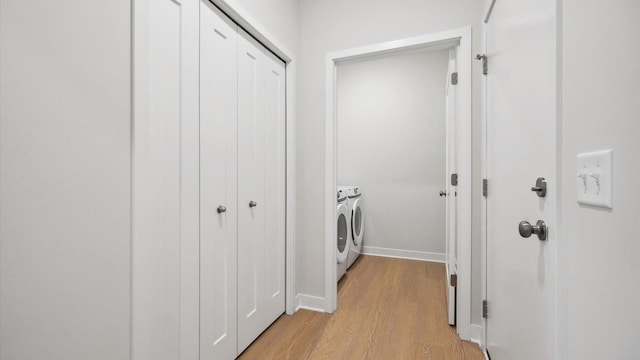 laundry room with light wood-type flooring and washer and clothes dryer