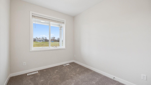 spare room with dark carpet