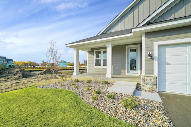 property entrance featuring a yard, a porch, and a garage