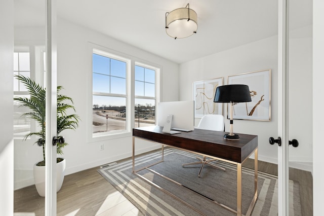 office area with french doors and light hardwood / wood-style flooring