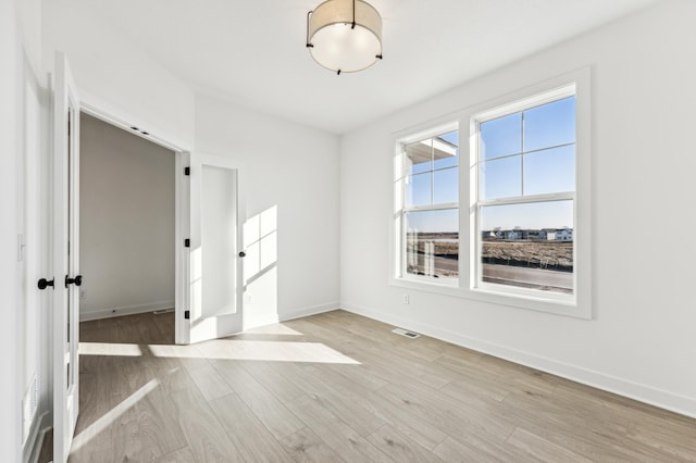 unfurnished room with light hardwood / wood-style floors