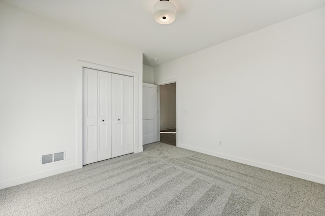 unfurnished bedroom with light carpet and a closet